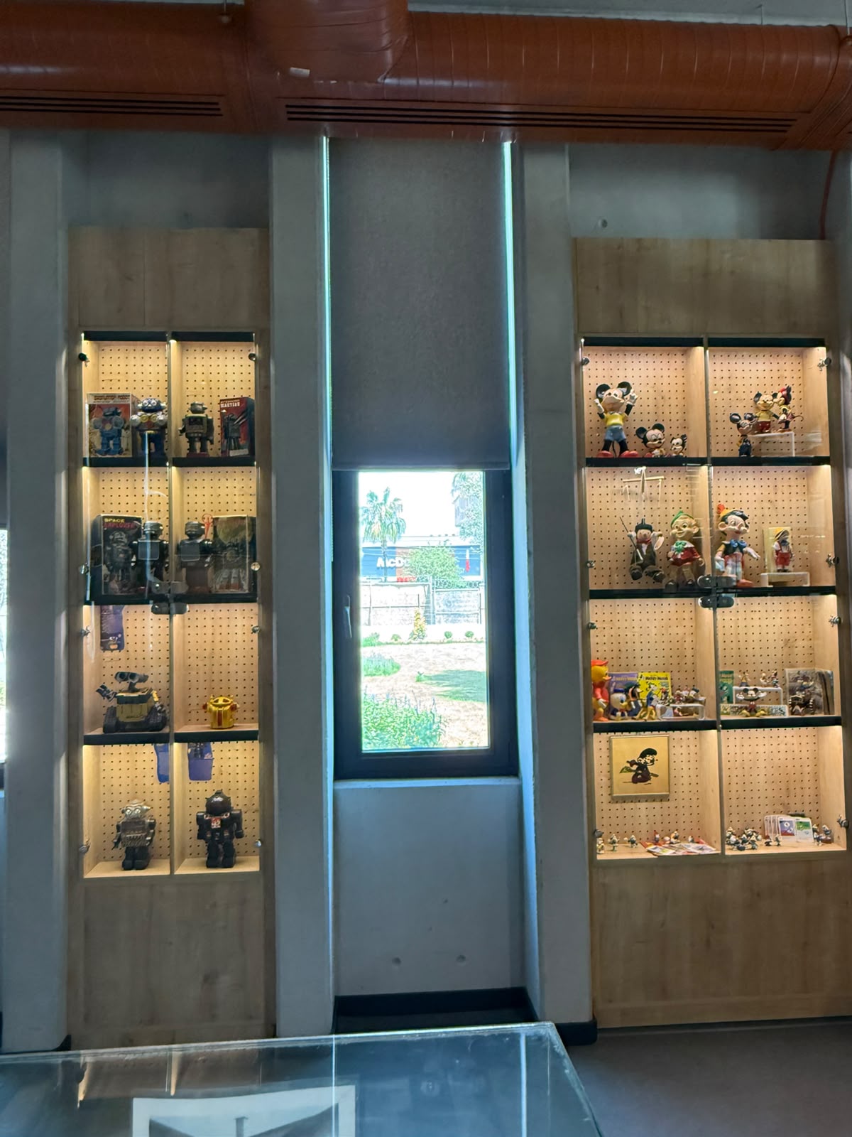 Cam vitrinlerde vintage robotlar, Disney figürleri ve teneke oyuncak araçlar